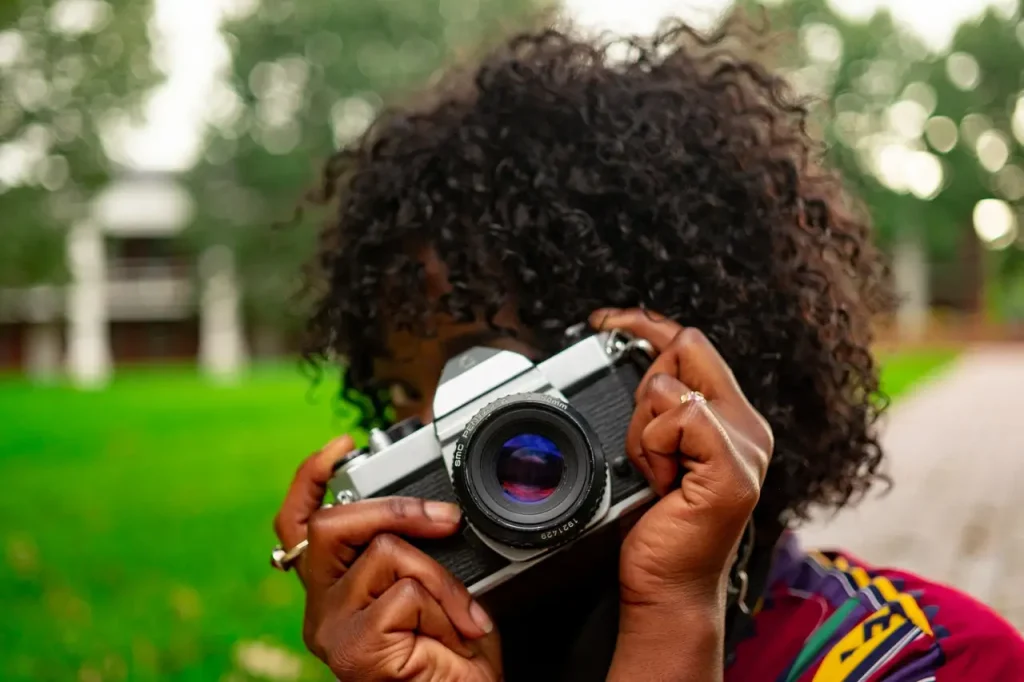 Woman holding classic film camera up to take photograph